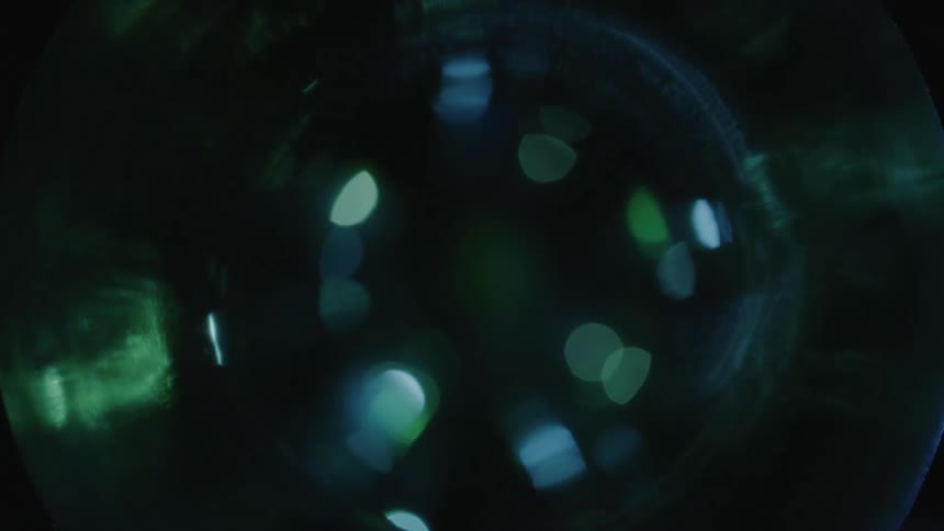 Light shines and reflects over a cristal ball on a dark room
