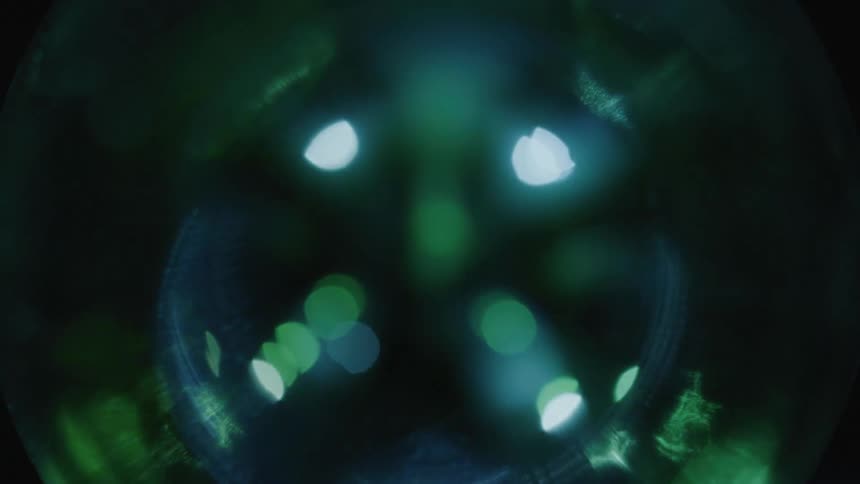 Close up of lights reflecting over a crystal ball on a dark background