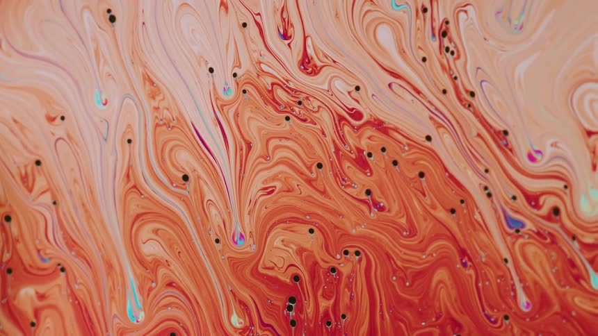 A liquid like paint with mixed colors of orangered blue and purple continue to mix together