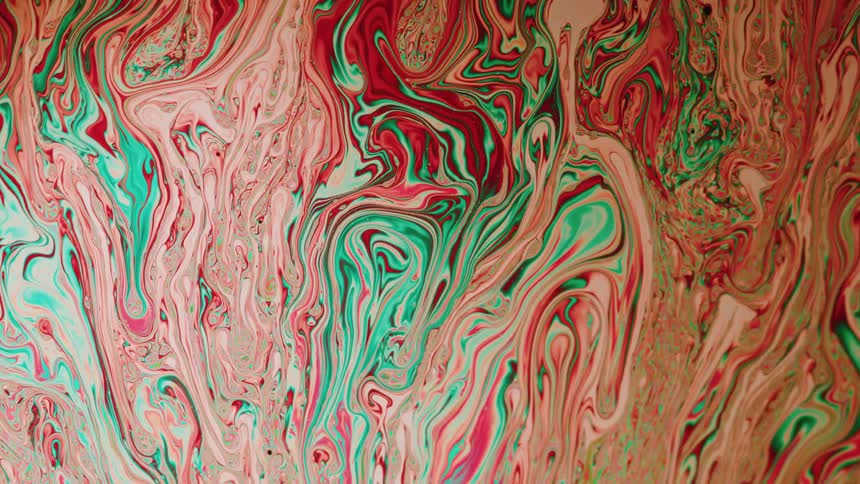 Multicolored streaks swirl on surface of mixture