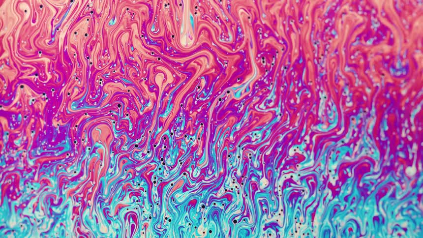 Bright colorful liquid ink flows forming abstract shapes