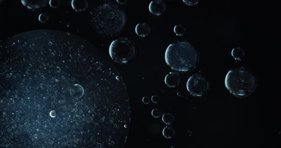 Blue burbles of different size formed underwater in the night