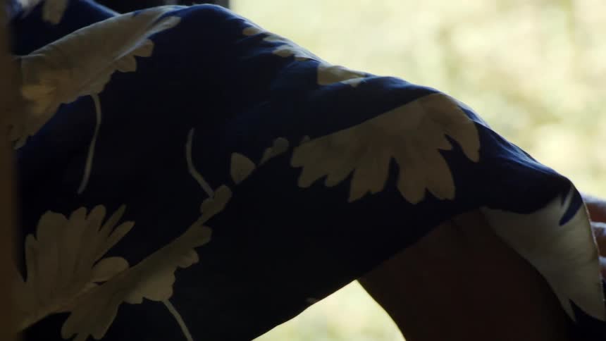 Closeup of a persons hands looking at a blue dress