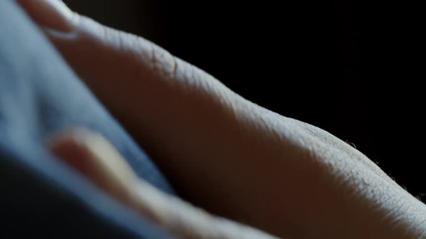 Human hands with reflection on the skin moving a type of fabric