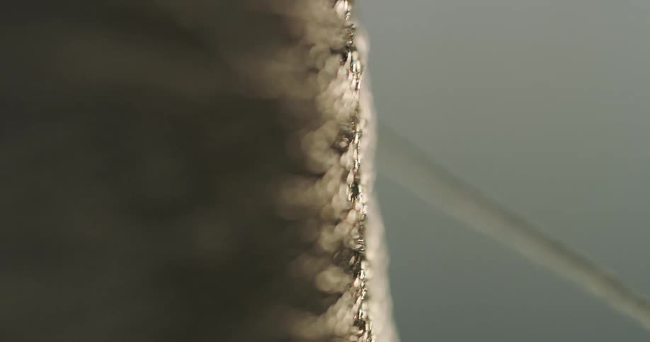 Close up of a thread of yarn coming from the spool