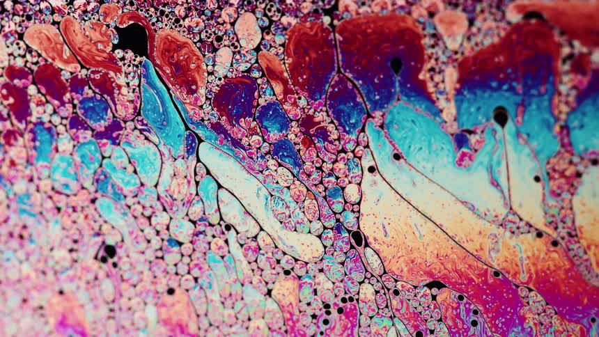 Bright colorful liquid ink flows forming abstract shapes