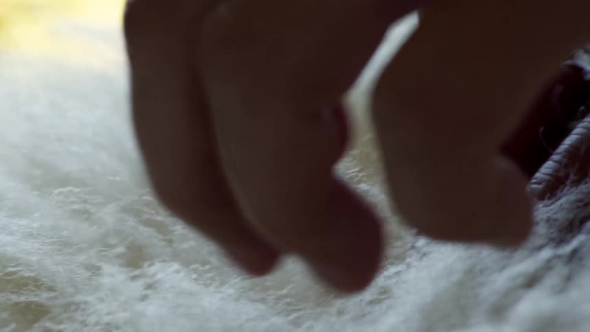 Closeup of hands smoothing a white fabric