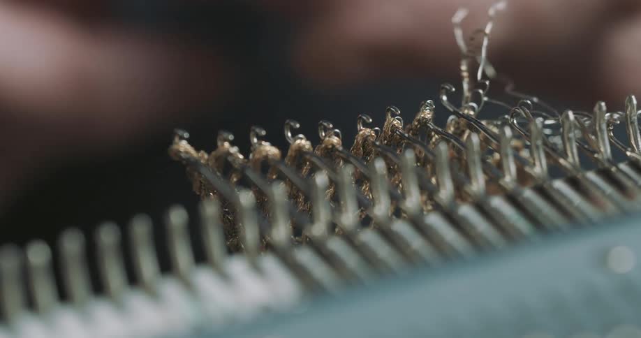 Fingers of a person handling a zipper in manufacturing