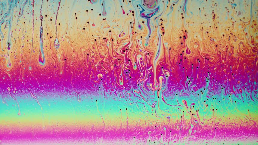 Bright colorful liquid ink flows forming abstract shapes
