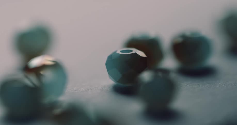 Beads roll on a table and rock as they move