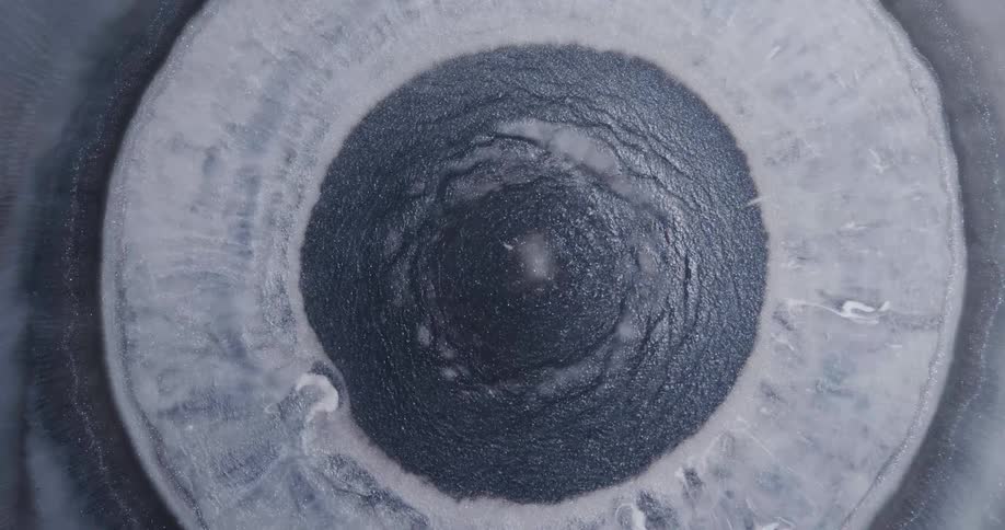 A gray circular object repelling and attracting particles around it