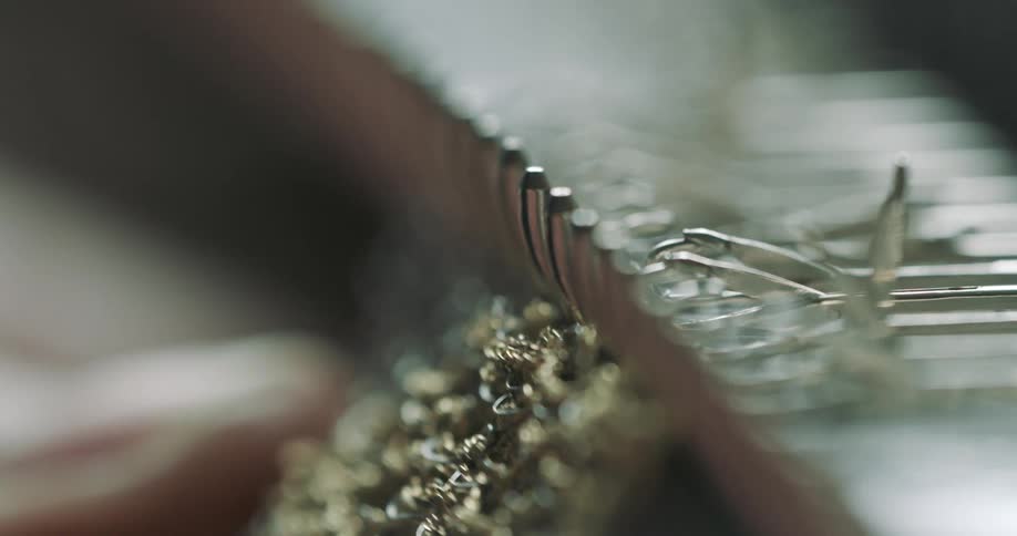A person is making jewelry with a machine