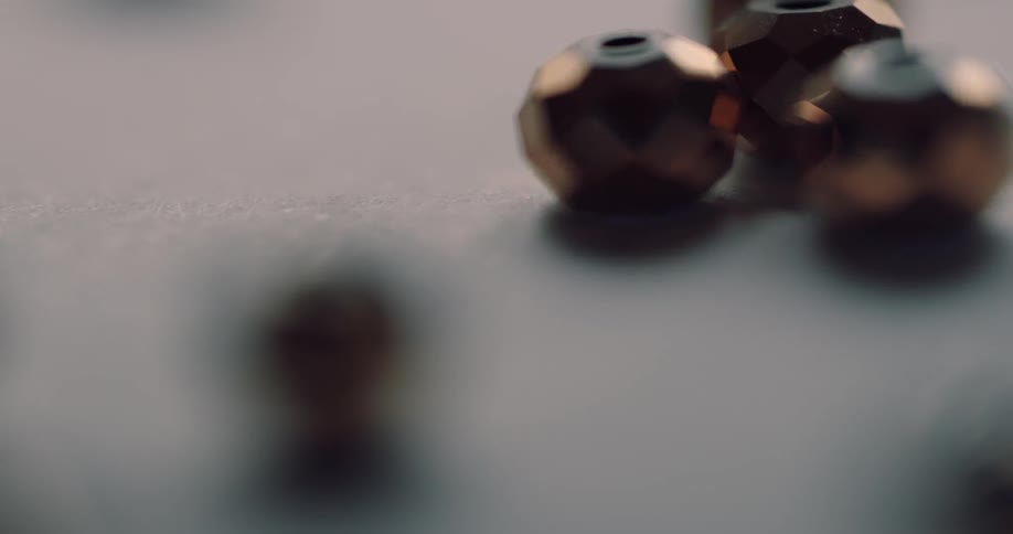 Faceted round beads on a surface blur in and out of focus