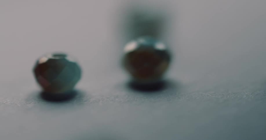 Texturedmetallic beads roll across surface