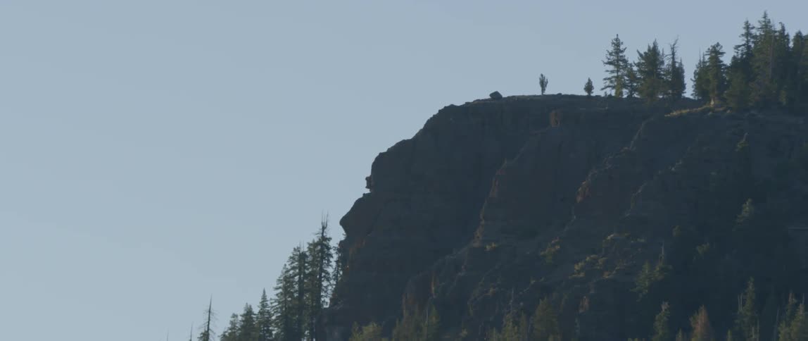 There is a large cliff in the distance on a sunny day