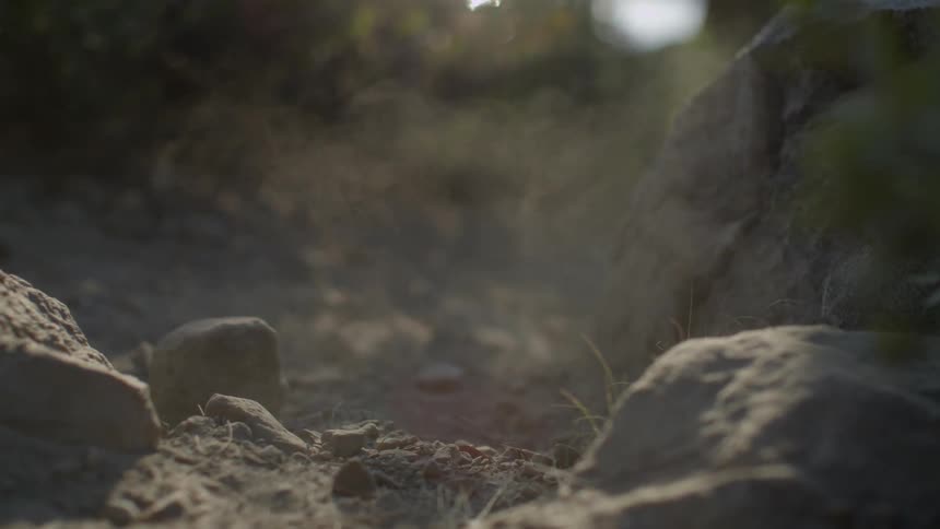 Dust swirls around rocks on the ground