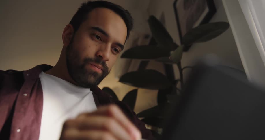 A man using a pen on an ipad indoor at midday