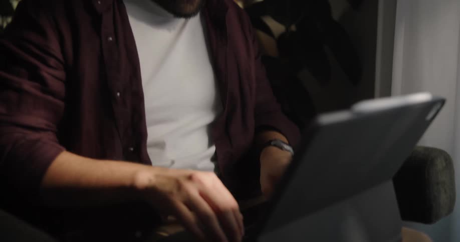 Man sitting smiling and using his laptop