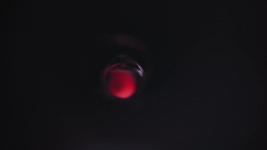 A red ball inside water spinning in the dark night