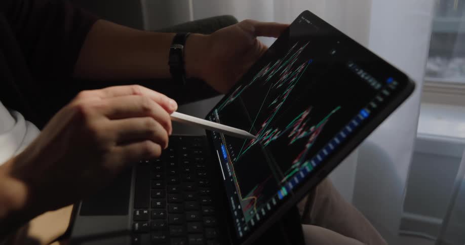 A man is using a stylus on a tablet