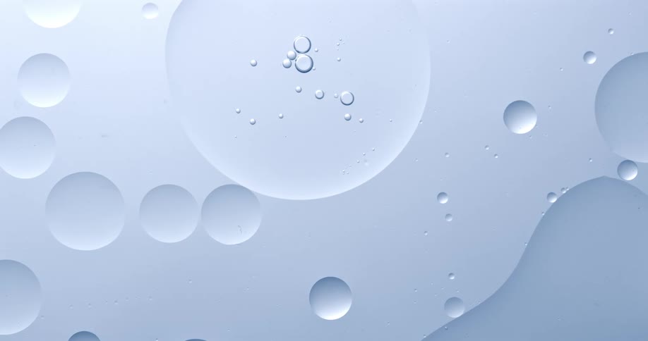 Bubbles on water flowing over a white surface with circles in it