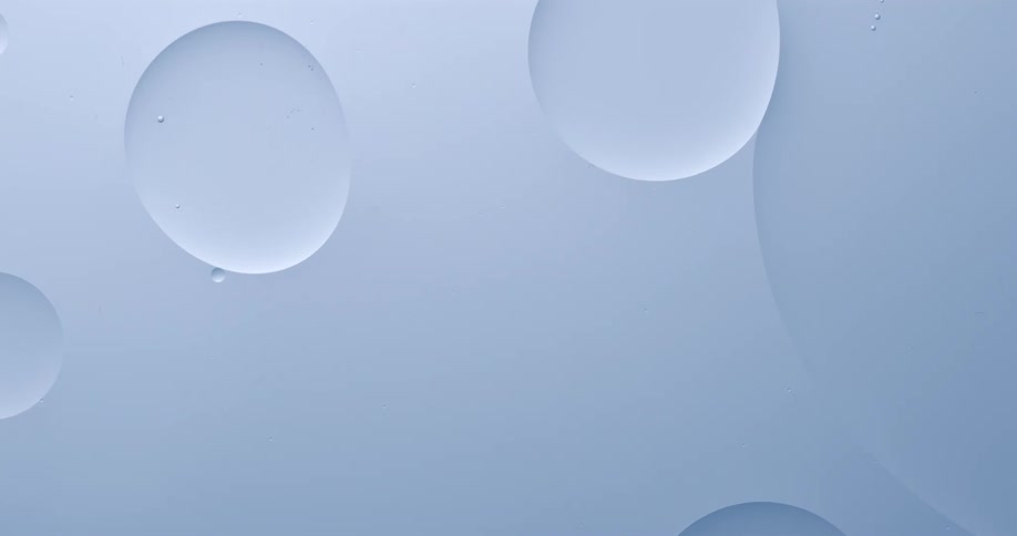 Two floating spheres merge into one in gray liquid