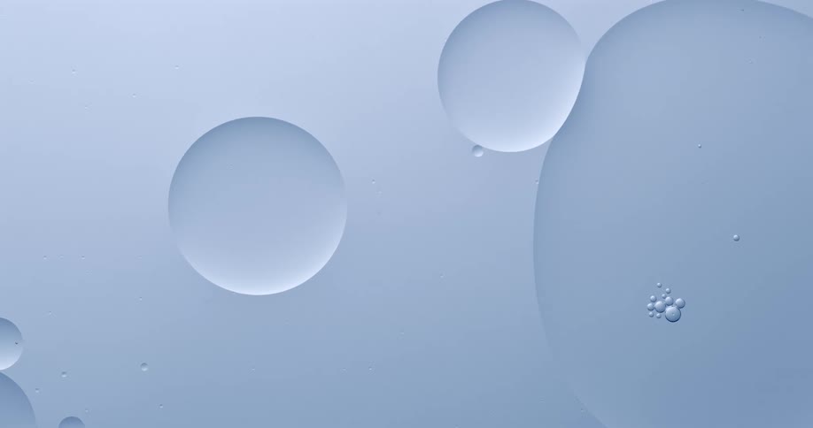 Some floating bubbles merge while others bounce off each other on blue liquid