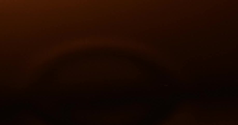 Two water drops fall into a body of dark red water