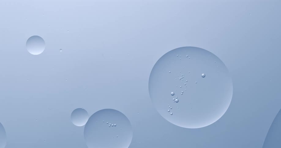 Orbs with small bubbles inside are floating as two spheres touch and merge into one