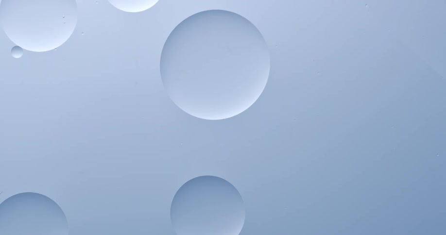 Orbs are floating in a white substance and two spheres merge as they touch