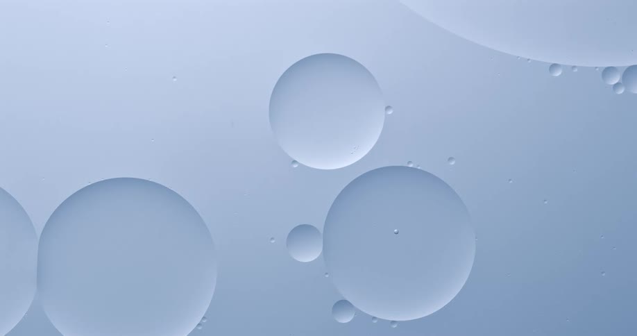 Large bubble absorbs another bubble while floating on blue background
