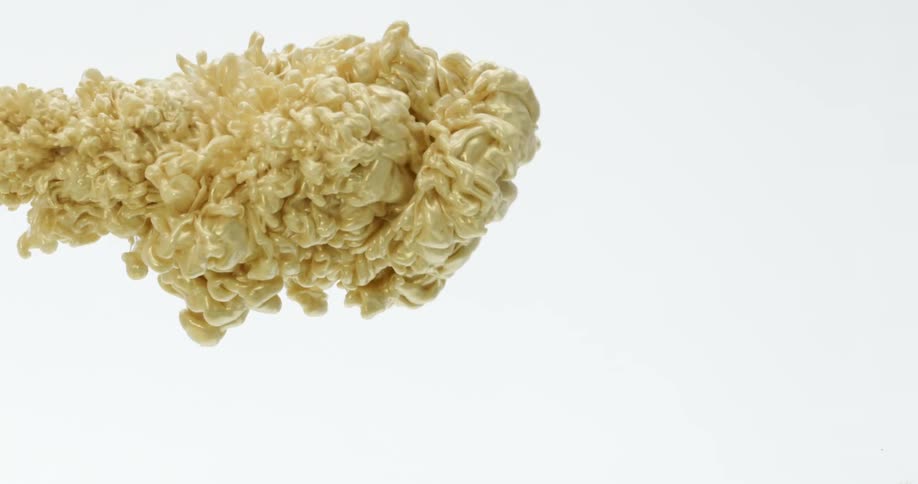 A gold color liquid like paint is injected into water with white background
