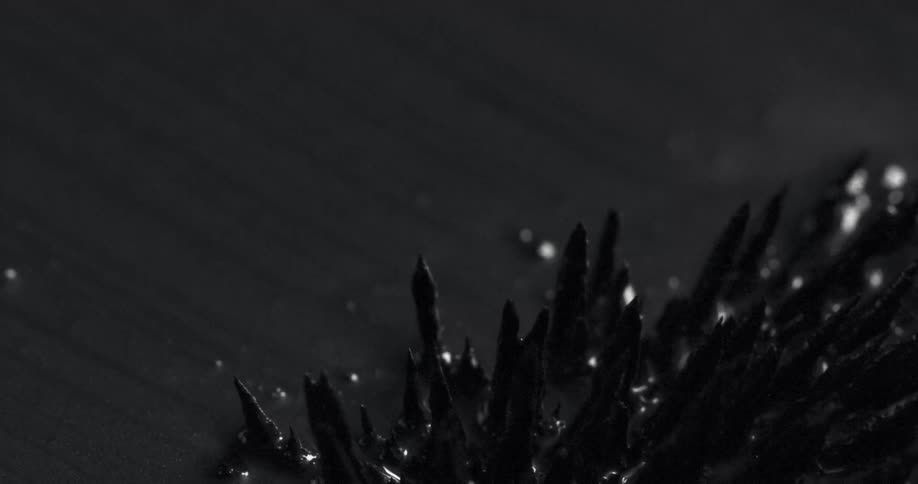 Black liquid texture with sharp shapes in abstract motion