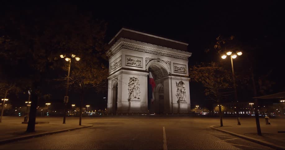 Empty roads lead to the arc de triomphe at night