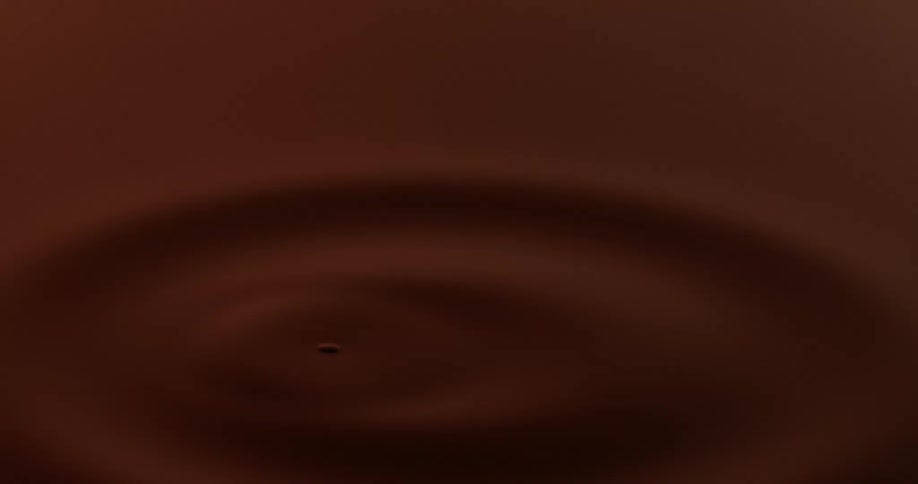 A drop of water falls into a dark red body of water