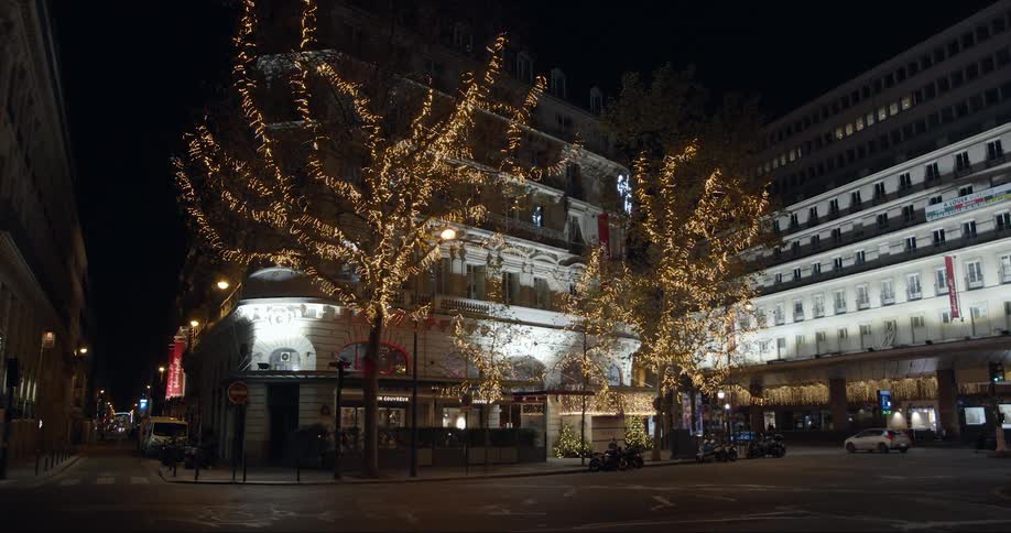 A car drives past the building at night
