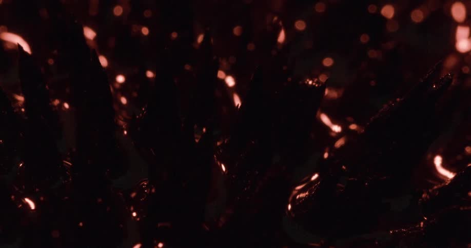 Light shines over round glass shapes on a black background