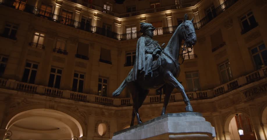 A sttue of a person in a horse in the middle or a circular building