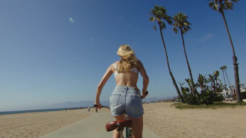 A woman riding a bicycle on the beach