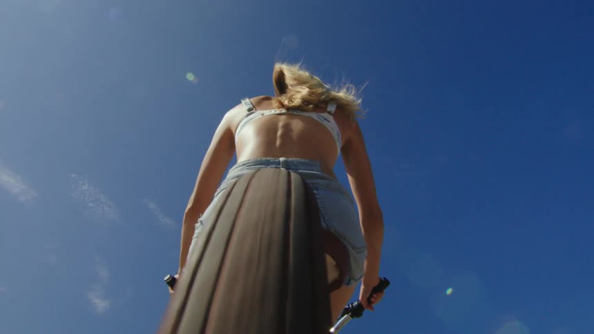 A female wearing shorts is riding a bike on a sunny day