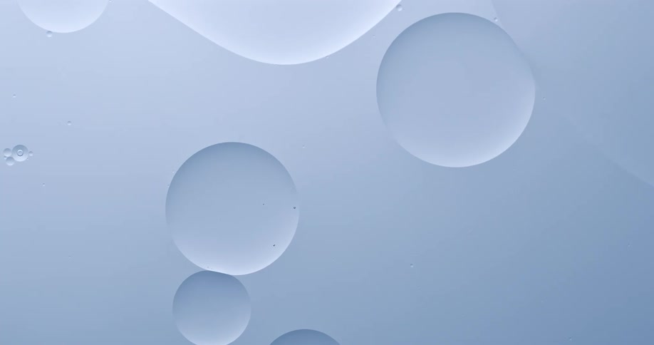 Bubbles or droplets floating in a clear still liquid collide and some merge