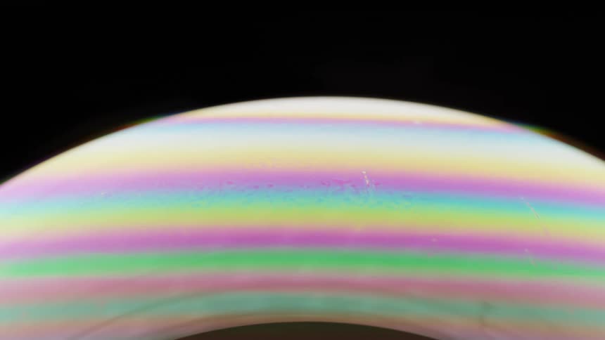 Light shines on a globe covered with soft fluorescent stripes as they move across the surface