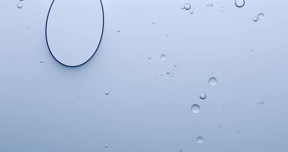 Orbs are floating in a liquid substance as small bubbles follow the shrinking sphere