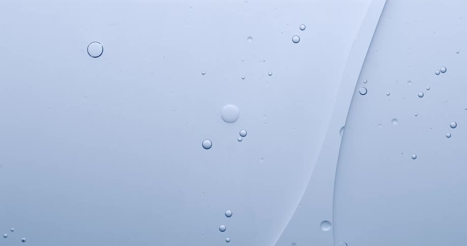 Drops of liquid float against a white background