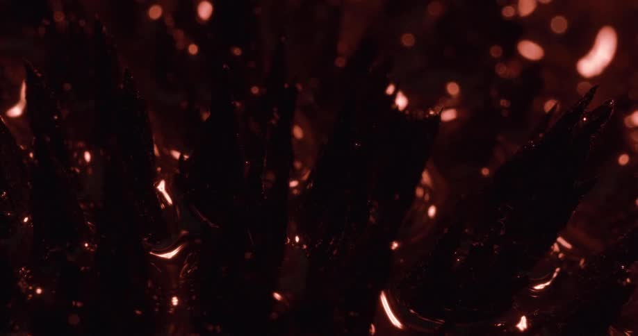 Dark liquid surrounding spikes reflects light as surface brightens