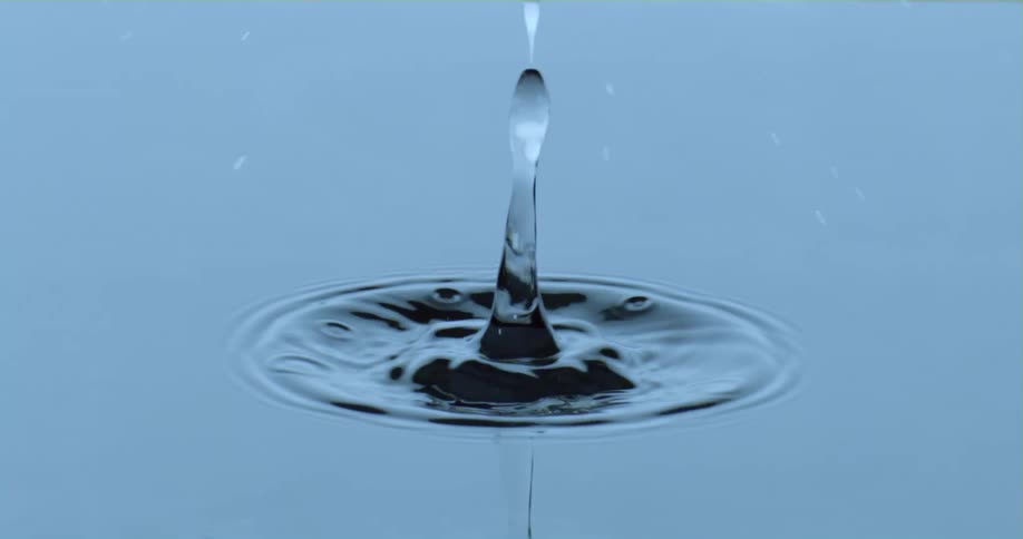 A drop of water falls into a body of water creating ripples
