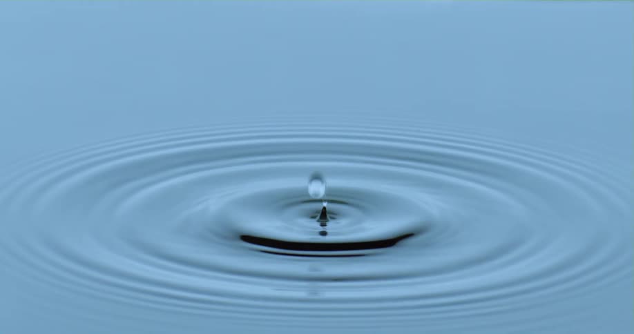 A droplet falls into a pool of water causing ripples