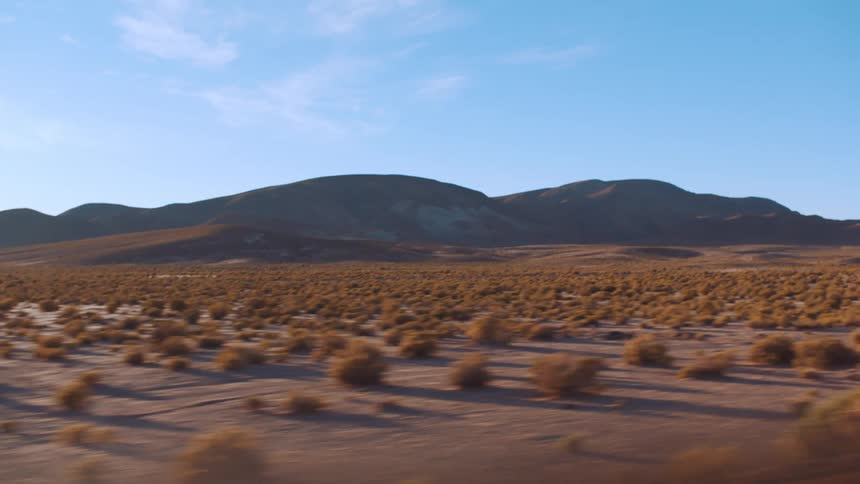 Mountain in front of blue sky and desert landscape