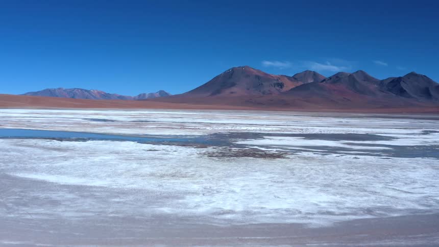 A mountain range behind a frozen body of water