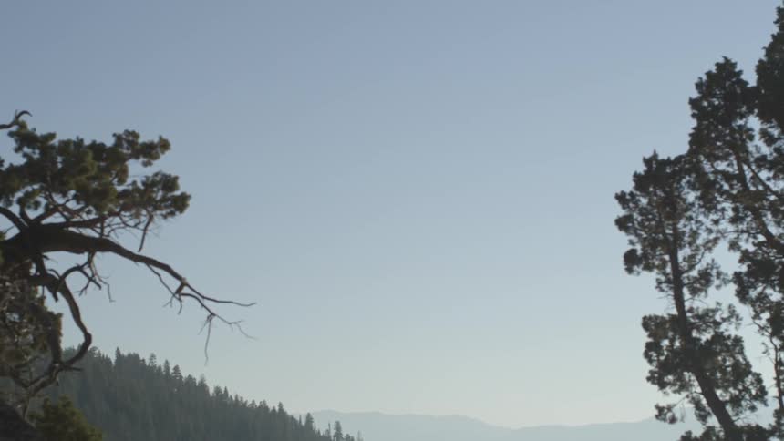 The sky is clear over the tree covered hills